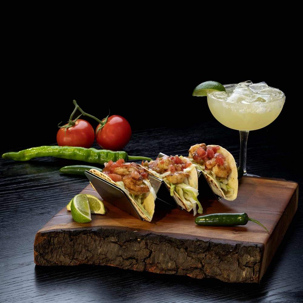 a plate of tacos  on a plate and a cocktail  on a table